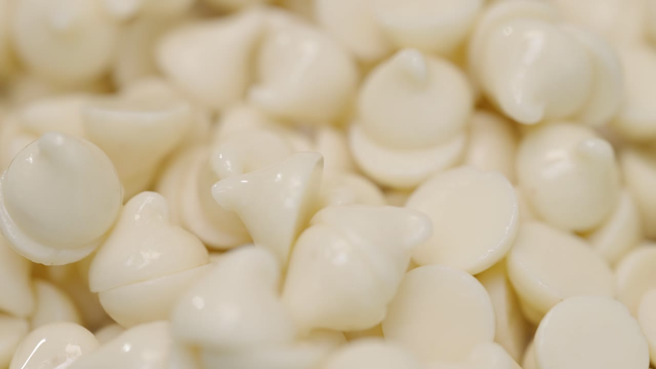 pila de chispas de chocolate blanco cálido que brillan en macro de luz de cerca 4k