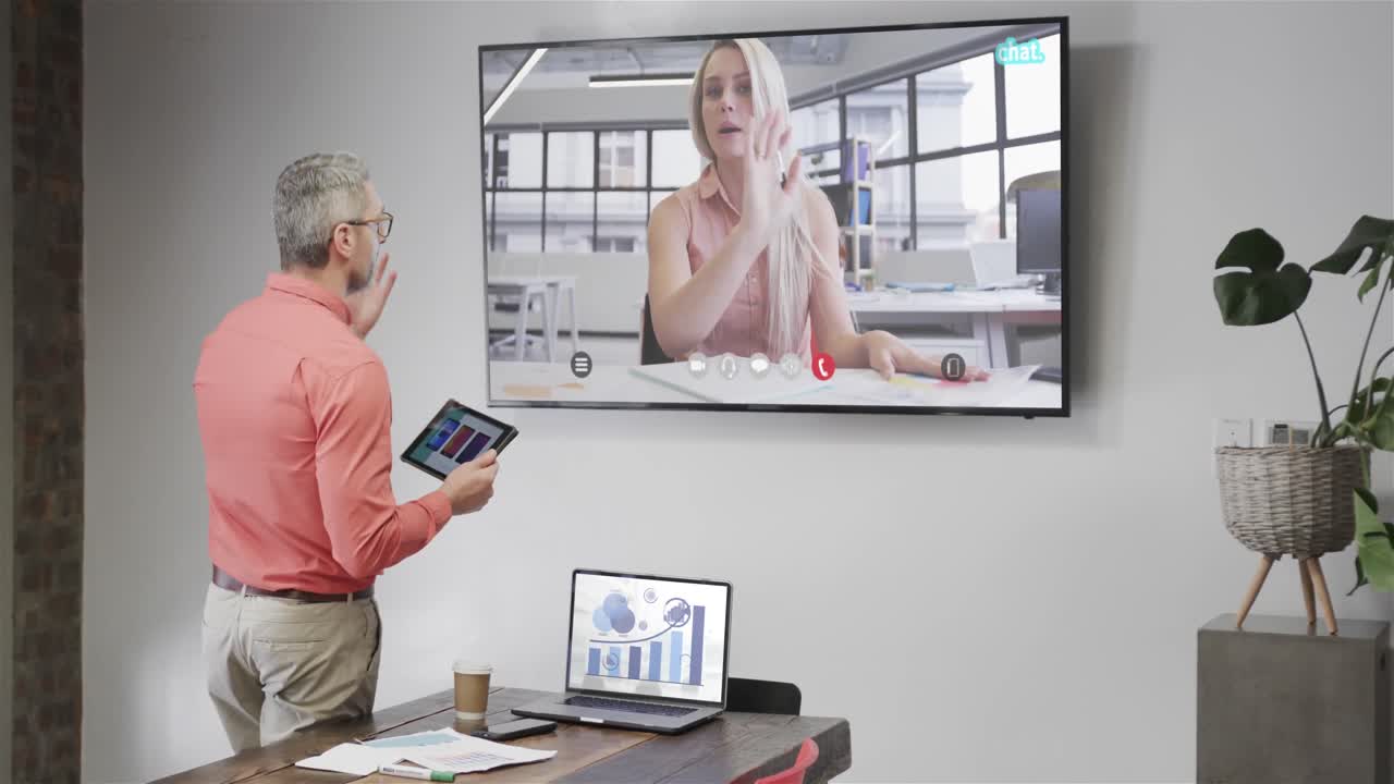 кавказский бизнесмен на видеозвонке с кавказской коллегой на экране телевизора