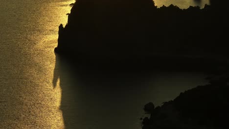 Puesta-De-Sol-Dorada-Sobre-El-Mar-Jónico,-Proyectando-Una-Serena-Silueta-De-La-Escarpada-Costa-De-La-Isla-De-Corfú