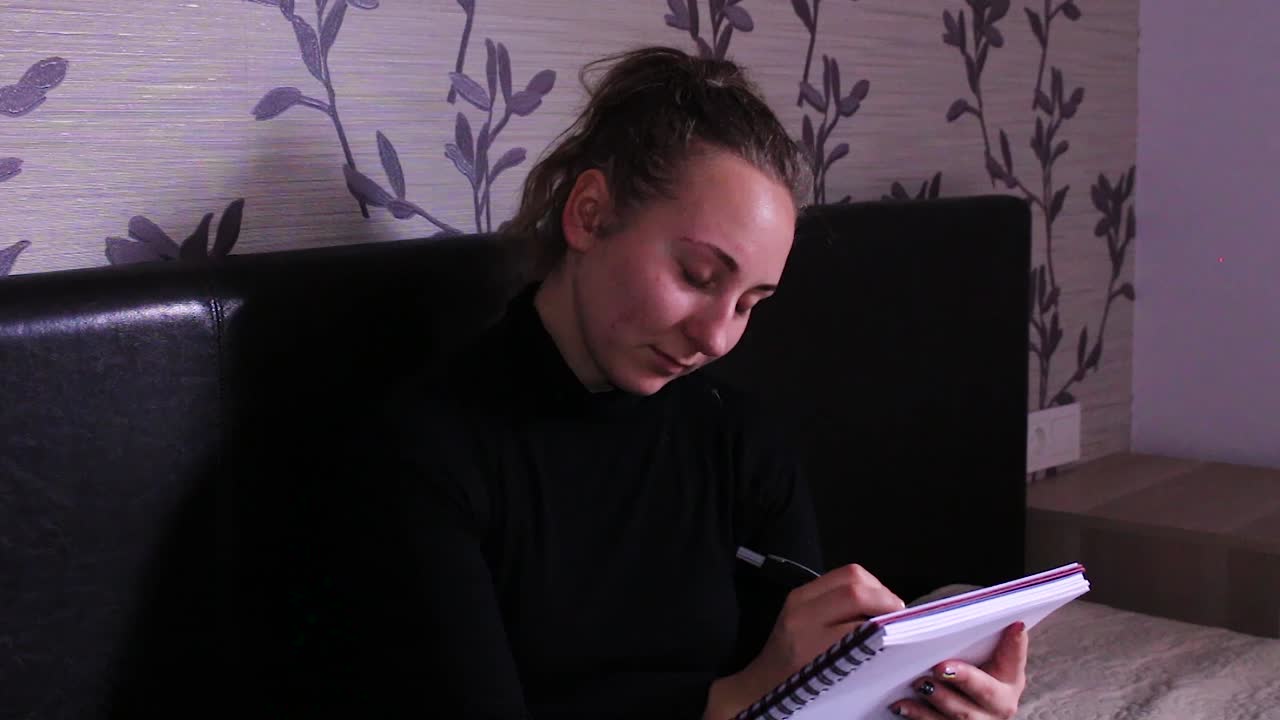 Teenage girl sitting down and taking notes