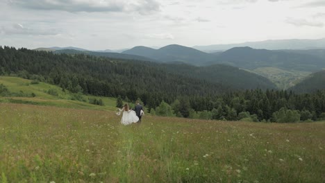 Groom-with-bride-go-for-a-picnic-on-a-mountain-hills.-Wedding-couple.-Family