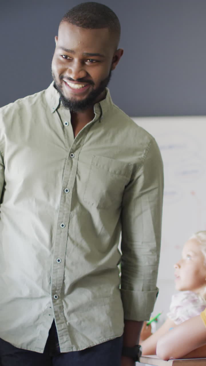 video de un feliz maestro afroamericano durante la lección con una clase de alumnos diversos