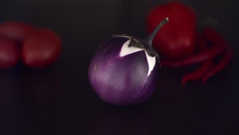 close up slider shot of a purple circular eggplant on a dark table - 4k