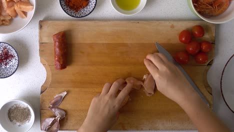 top down view of male hands taking and placing pieces of chicken into bowl