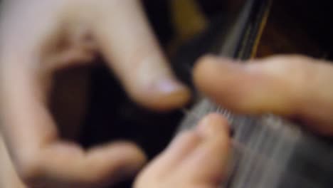 close-up of hands playing a guitar