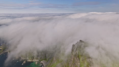 stave norway v18 vista cinematográfica prístina del paisaje, un dron vuela alrededor del mirador de la cumbre de måtind capturando escarpadas crestas montañosas cubiertas de una gruesa capa de niebla blanca - rodada con mavic 3 cine - junio de 2022