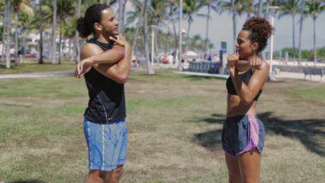 couple stretching arms on lawn