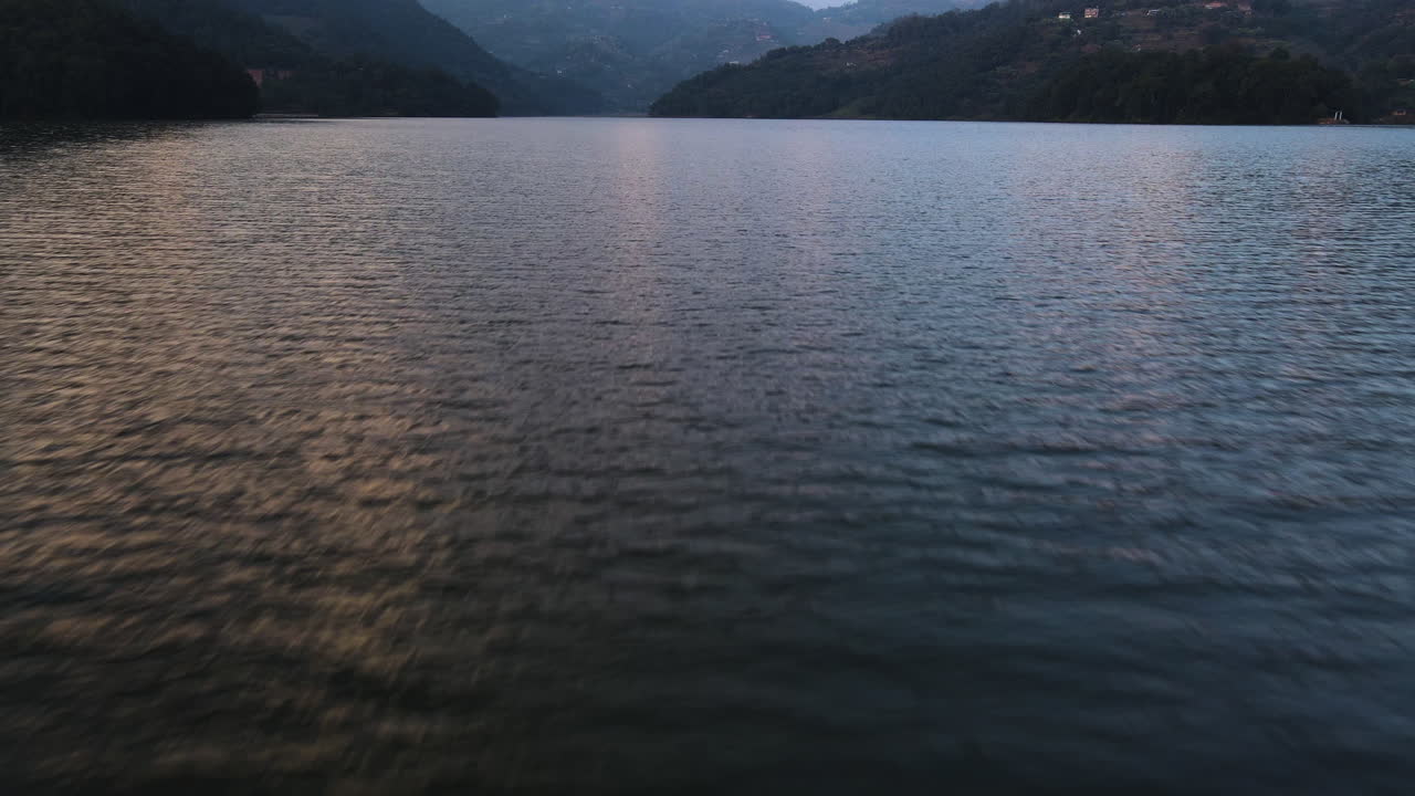 A Tranquil View of Phewa Lake Set Against the Himalayan Mountains at Sunset in Pokhara, Nepal - Drone Flying Forward