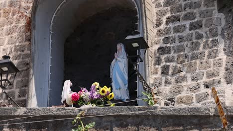 statue of mother mary adorned with flowers