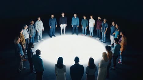 diverse group of people standing in a circle in a spotlight