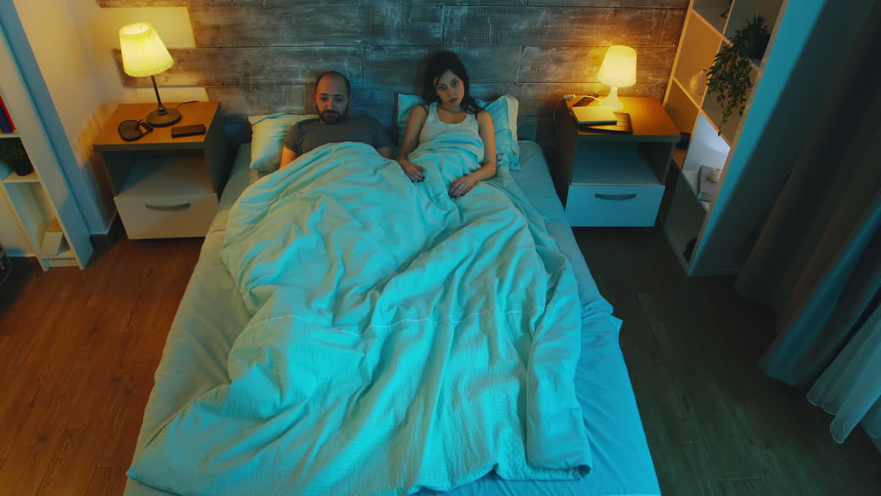 joven esposa con su marido bajo la sábana