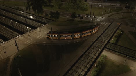 a streetcar turns into a modern covered depot during the late evening