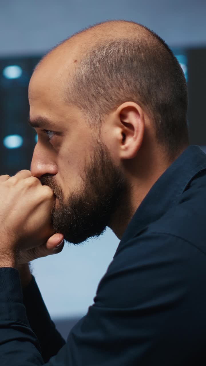 Focused Man Thinking Deeply in a Dark Technology Office