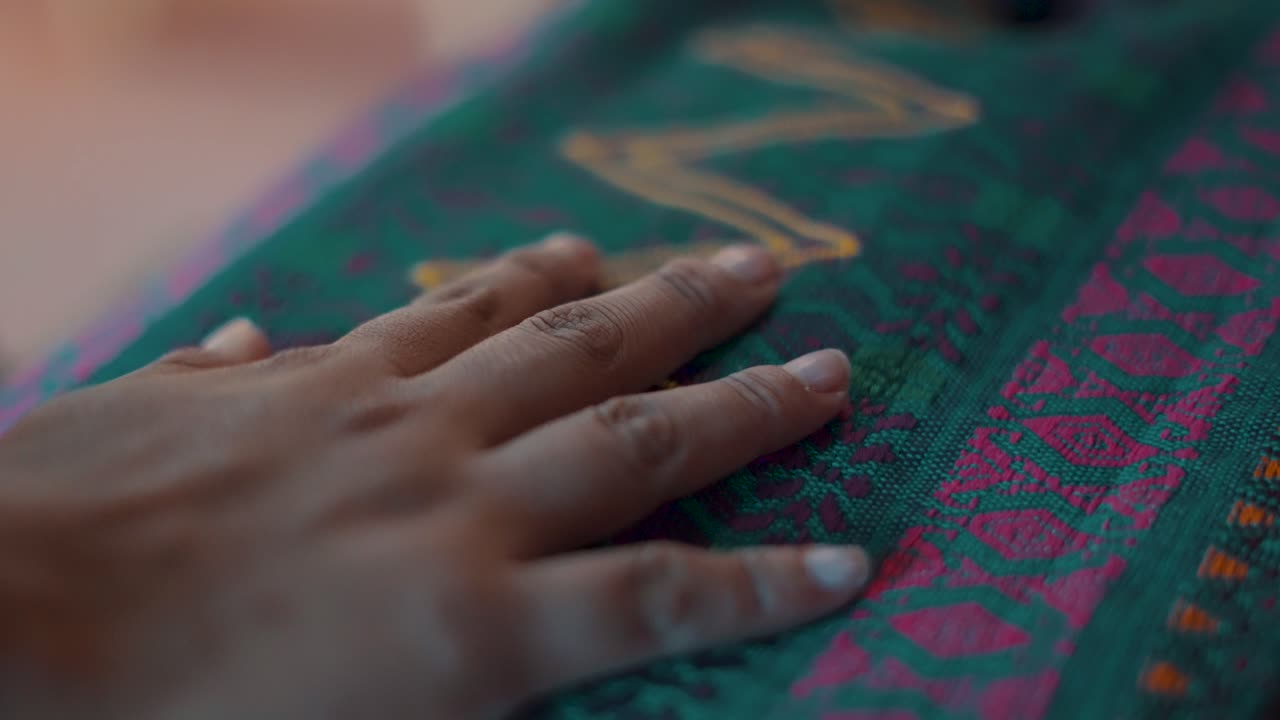 mano de mujer maya tocando un colorido textil guatemalteco hecho a mano - cámara lenta de cerca