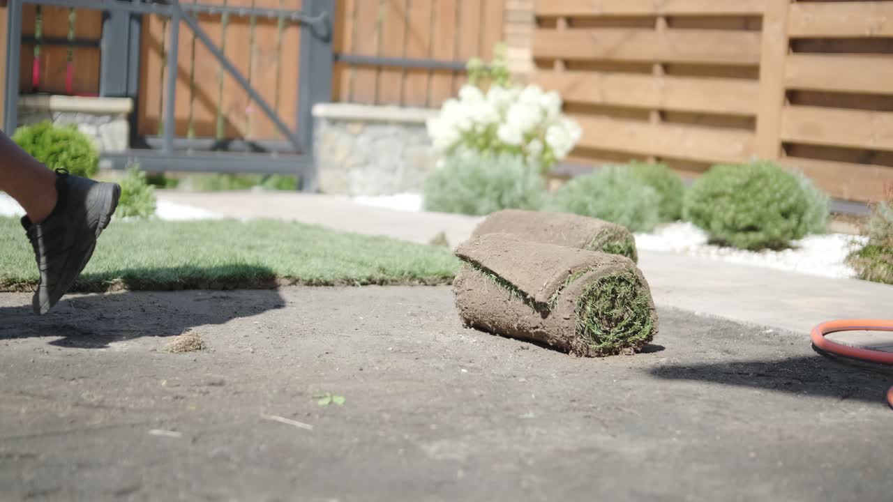 hombre colocando césped en el jardín del patio trasero para la instalación de césped y proyecto de jardinería, centrado en la mejora del hogar y el mantenimiento al aire libre para un césped fresco y verde en un patio residencial
