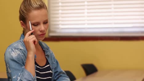 blonde student taking notes in classroom