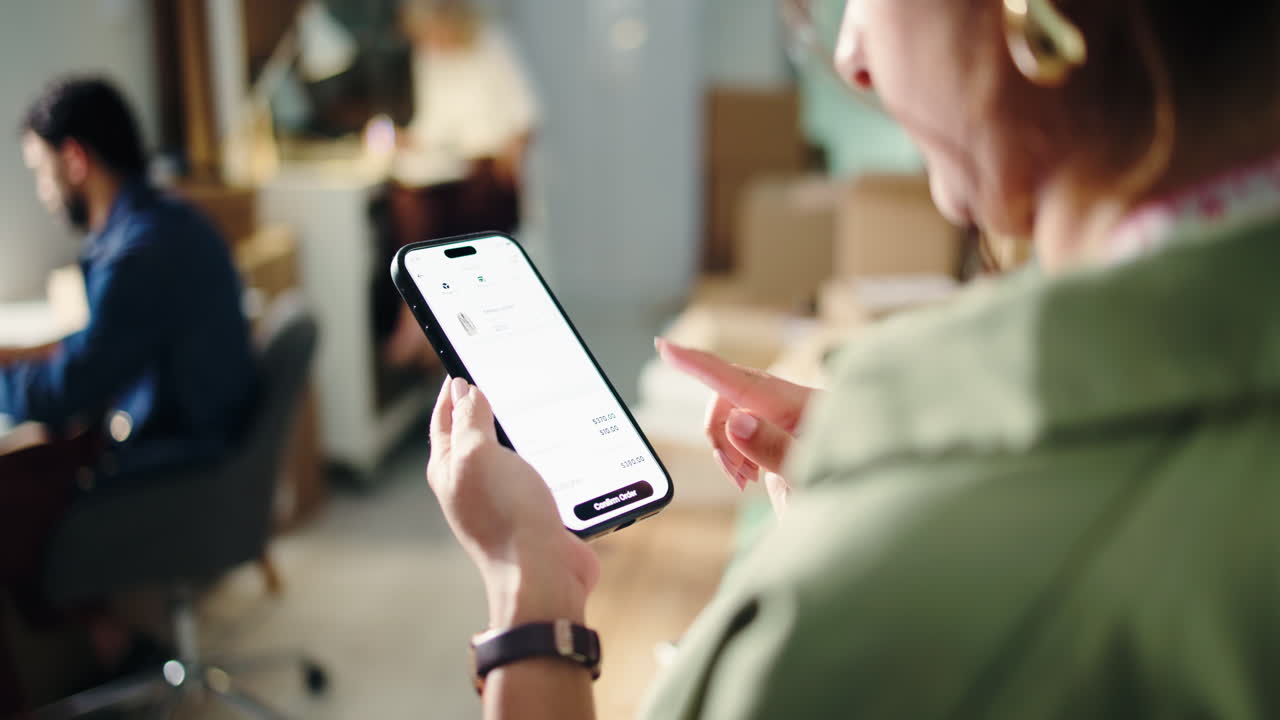 Donna che fa acquisti online di abbigliamento su smartphone in ufficio