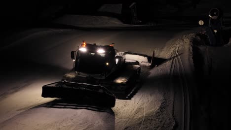 máquina de nieve trabajando a través de la oscuridad de la noche, montañas dolomitas, italia