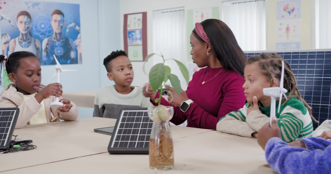 Teacher with children picking up and spinning turbine, guiding children's hands to explore energy