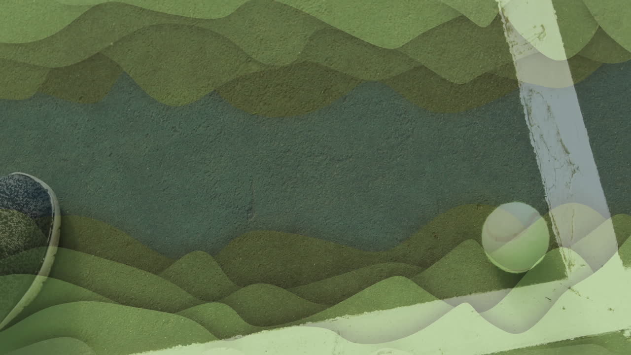 Tennis ball resting near boundary line, highlighting textured green court surface with shoe tip