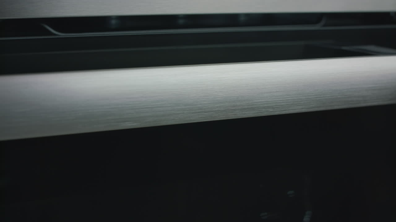 close-up de um cabo de forno de metal escovado câmera transportando à direita