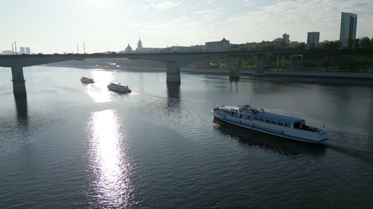 Boats Navigating a River Under a Bridge with City Skyline