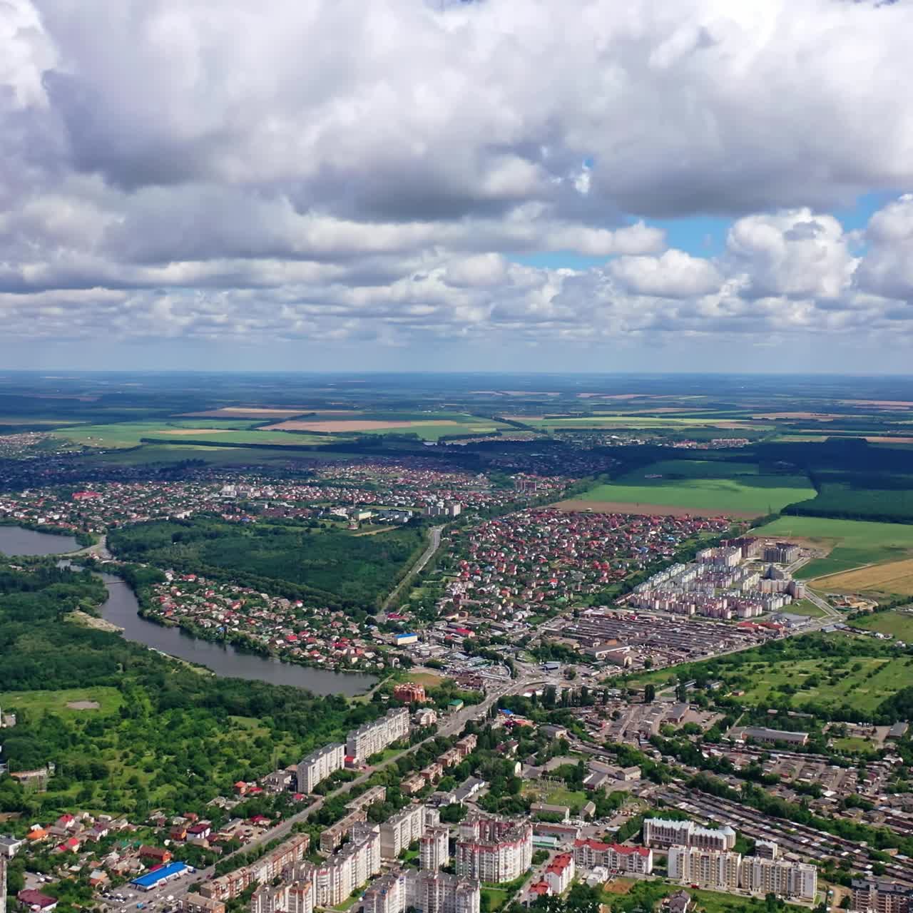 City landscape in summer. River flowing in the city. View from above on the city on the beautiful nature background. Aerial view.