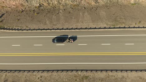 Vertical-drone-view-of-highway-with-few-cars-driving-fast-between-white-lines