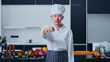 una mujer asiática gritando a la cámara en la cocina de su casa.