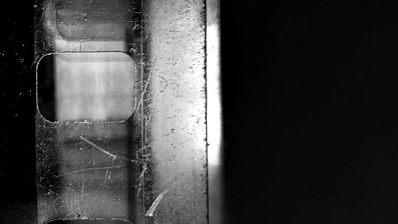 Primo piano di striscia di pellicola vintage 35mm che scorre in un proiettore