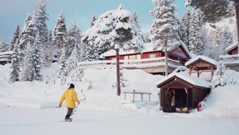 Winterly-Rural-Landscape-With-A-Man-Carrying-Auger-Drill-Towards-The-Cabin