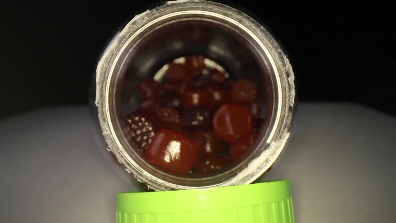 moviéndose más allá de la tapa, empujando lentamente dentro de una botella de multivitaminas para adultos