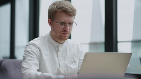 внештатный писатель или журналист работает с ноутбуком в кафе или офисе портрет симпатичного мужчины с блокнотом, печатающим текст