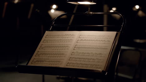 music stand with sheet music on a dark stage