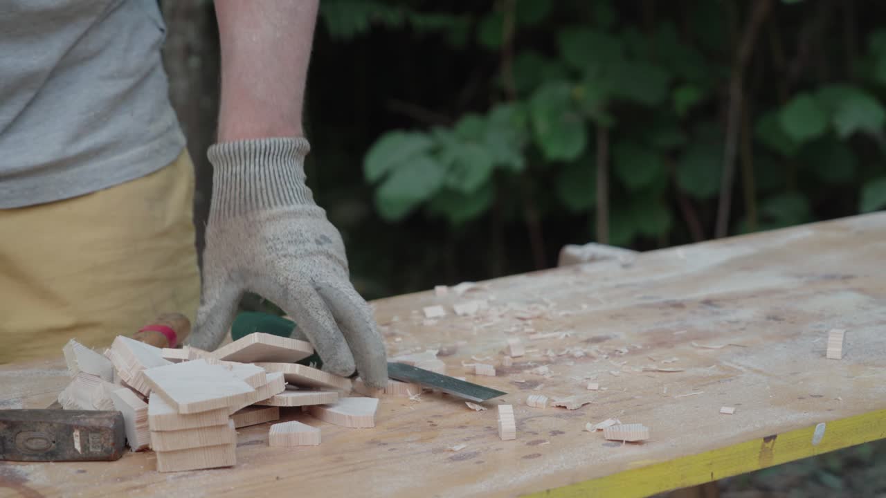 Artisan brushes wood surface clean removing fresh chips during outdoor woodworking process