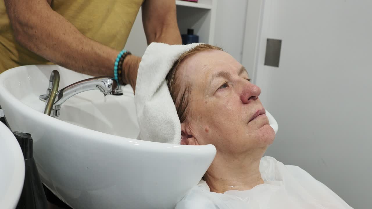 mujer lavándose el cabello en un salón