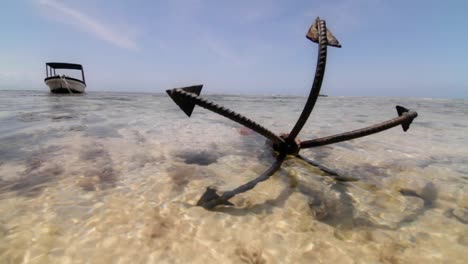 close up of anchor at low tide with boat