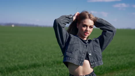 portrait of a sexy model outdoors. beautiful young woman posing on camera on the background of green field. attractive girl in the countryside.