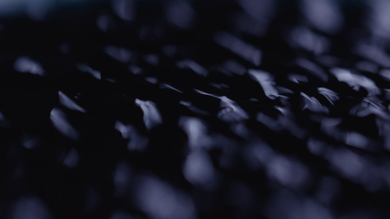 Macro of black fluid with increasing speed of ripples on the surface