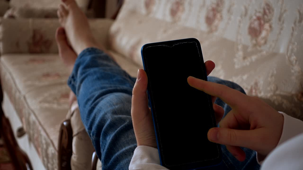 십대는 스마트 폰에서 정보를보고 있습니다. 알파 채널이 포함되어 있습니다. 스마트 폰 화면에 비디오를 입 할 수 있습니다.