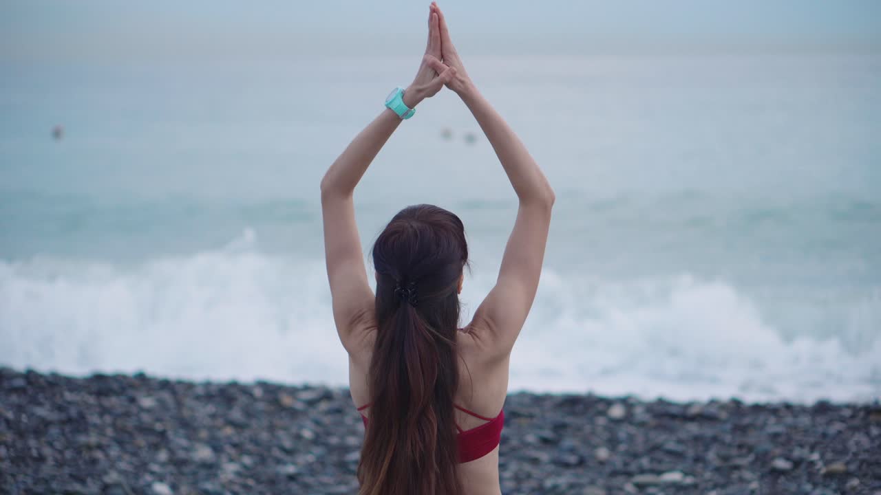 mujer estirándose en la playa