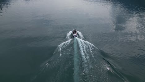 Close-up-of-a-tourist-boat-and-man-water-skiing-on-a-Switzerland-lake