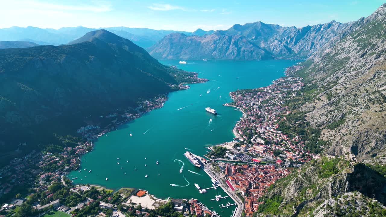 Aerial view of famous travel destination Kotor. Situated in Montenegro. Panoramic view of all region. Luxury cruise ships and yachts. Turquoise water. Drone forward