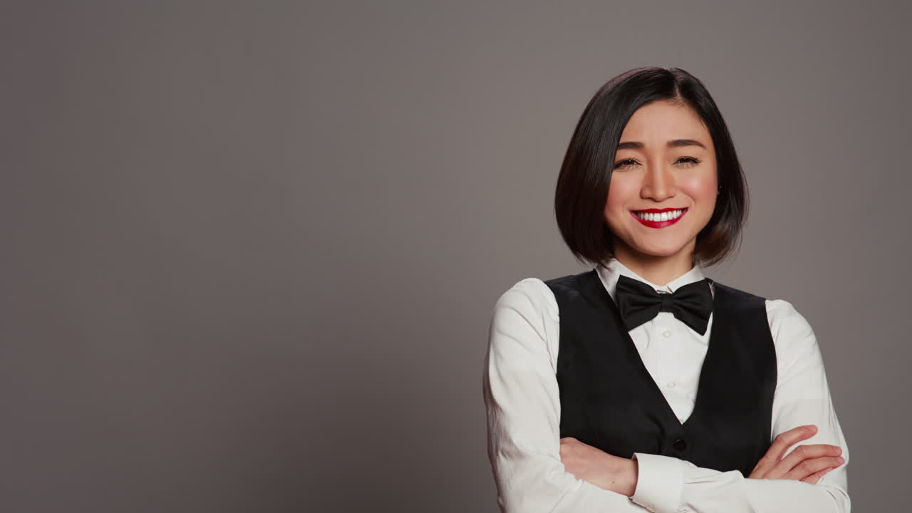 La receptionist asiatica posa con le braccia incrociate davanti alla telecamera