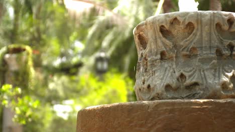 A-small-white-stone-fountain-in-a-botanical-garden