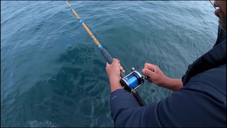 enrollando un carrete de pesca convencional en cámara lenta