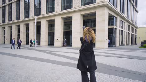 woman taking photos in a city square