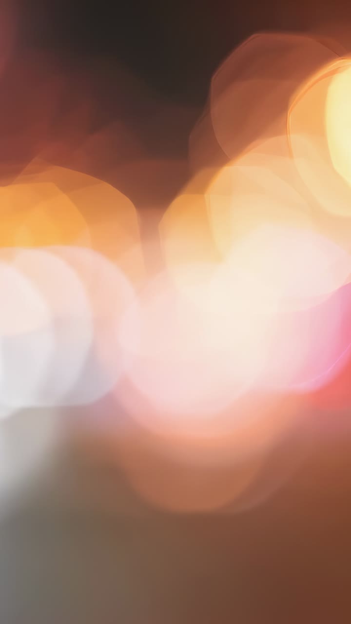 Vertical video: Displaying warm toned bokeh filling full frame, softly creating dreamlike pattern