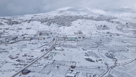 Toma-Aérea-De-Un-Ramat-Hagolan-Cubierto-De-Nieve-Con-Mt-Hermon-En-El-Fondo,-Israel