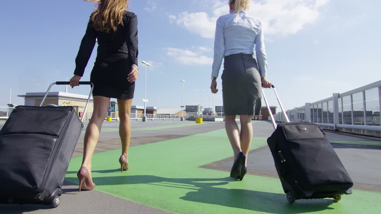 mujeres de negocios en el estacionamiento del aeropuerto listas para los negocios